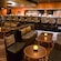 A large, spacious lounge features leather sofas, comfortable chairs and a long bar